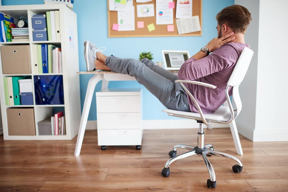 Mann sitzt gechillt bei Tisch
