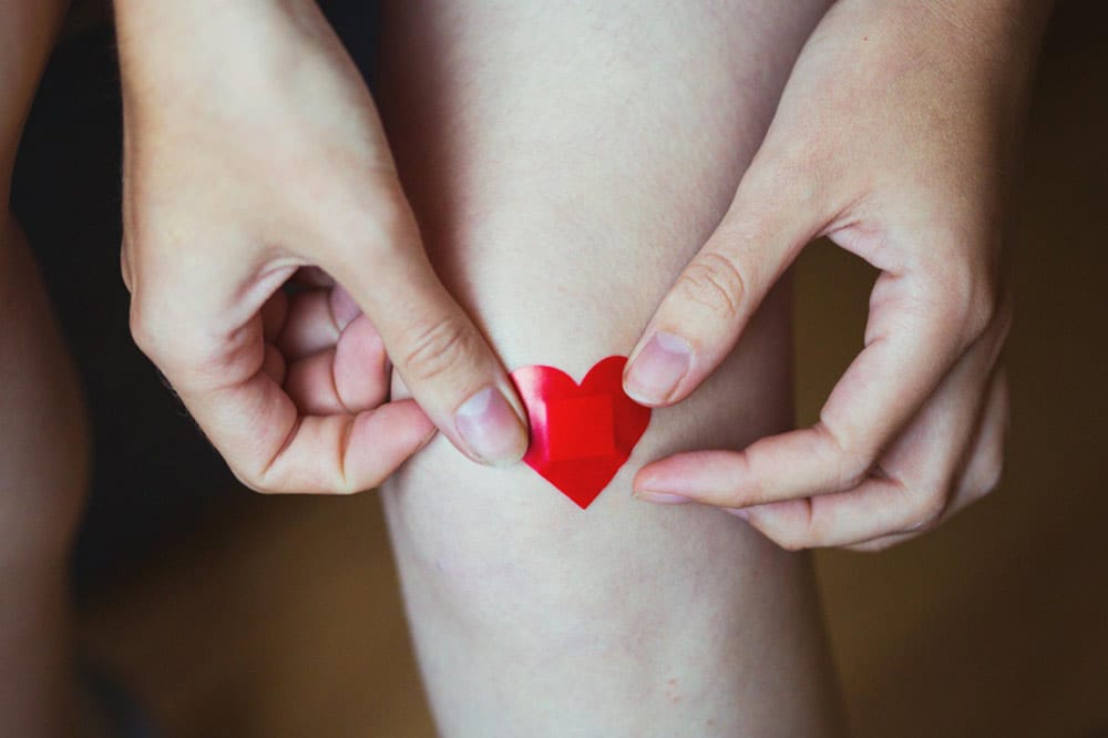 Hände nehmen Rücksicht auf das Knie